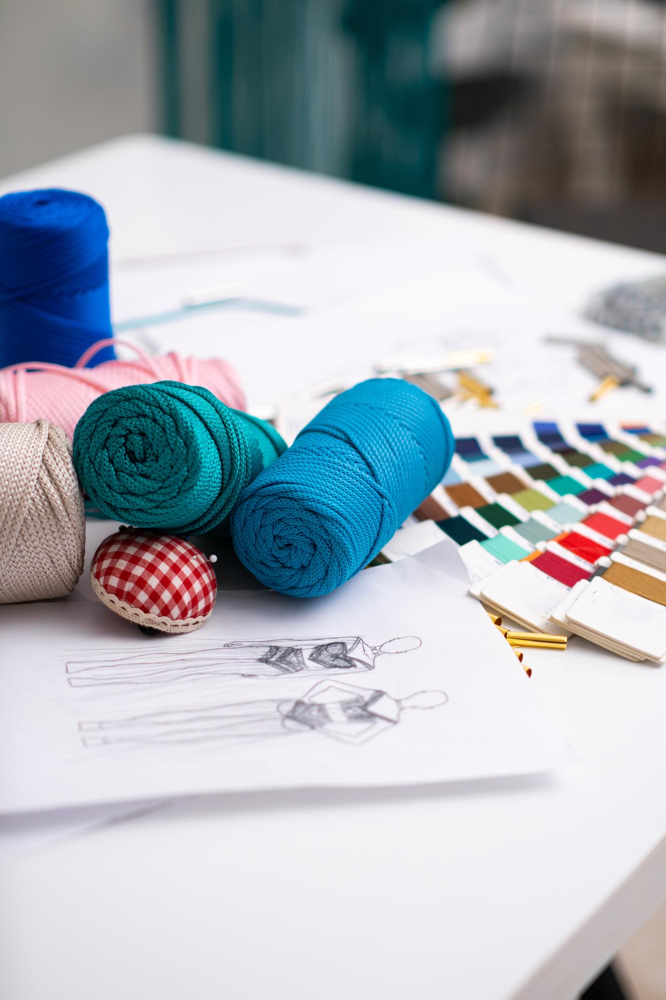 Atelier workspace with thread spools and sketches